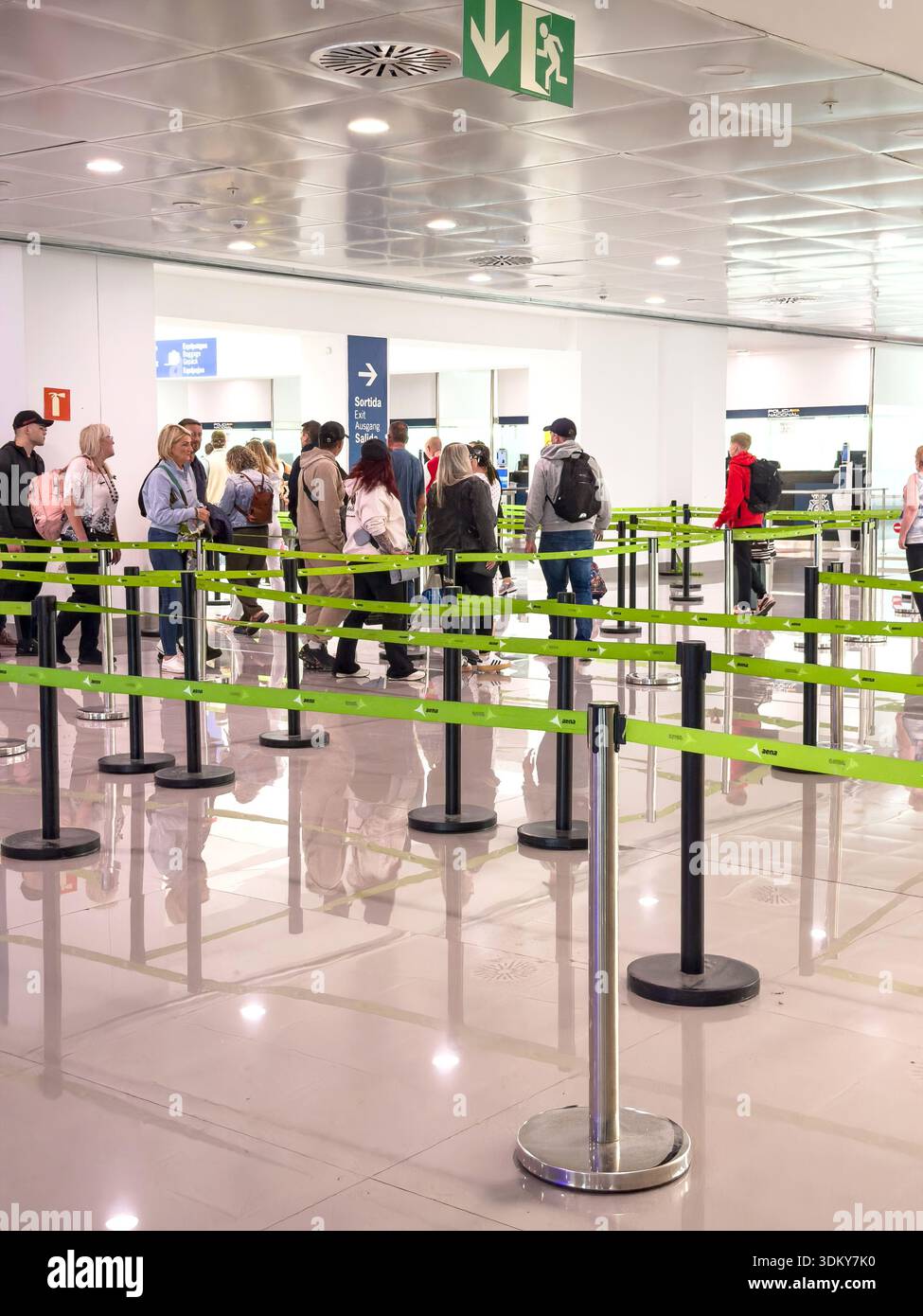 Passeggeri in fila nell'area di check-in dell'aeroporto, frontiera UE EES, atmosfera vivace piena di viaggiatori, sistema di ingresso e uscita, ritardi di viaggio - Immagine stock catturata con smartphone
