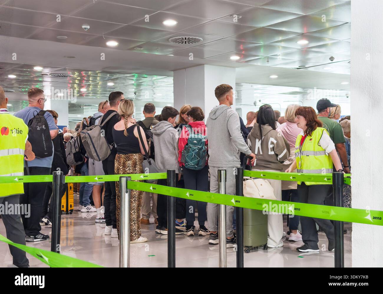 Un affollato terminal aeroportuale pieno di viaggiatori in attesa in fila, controlli di viaggio e di sicurezza EES sistema di ingresso europeo EU - Immagine stock catturata con smartphone