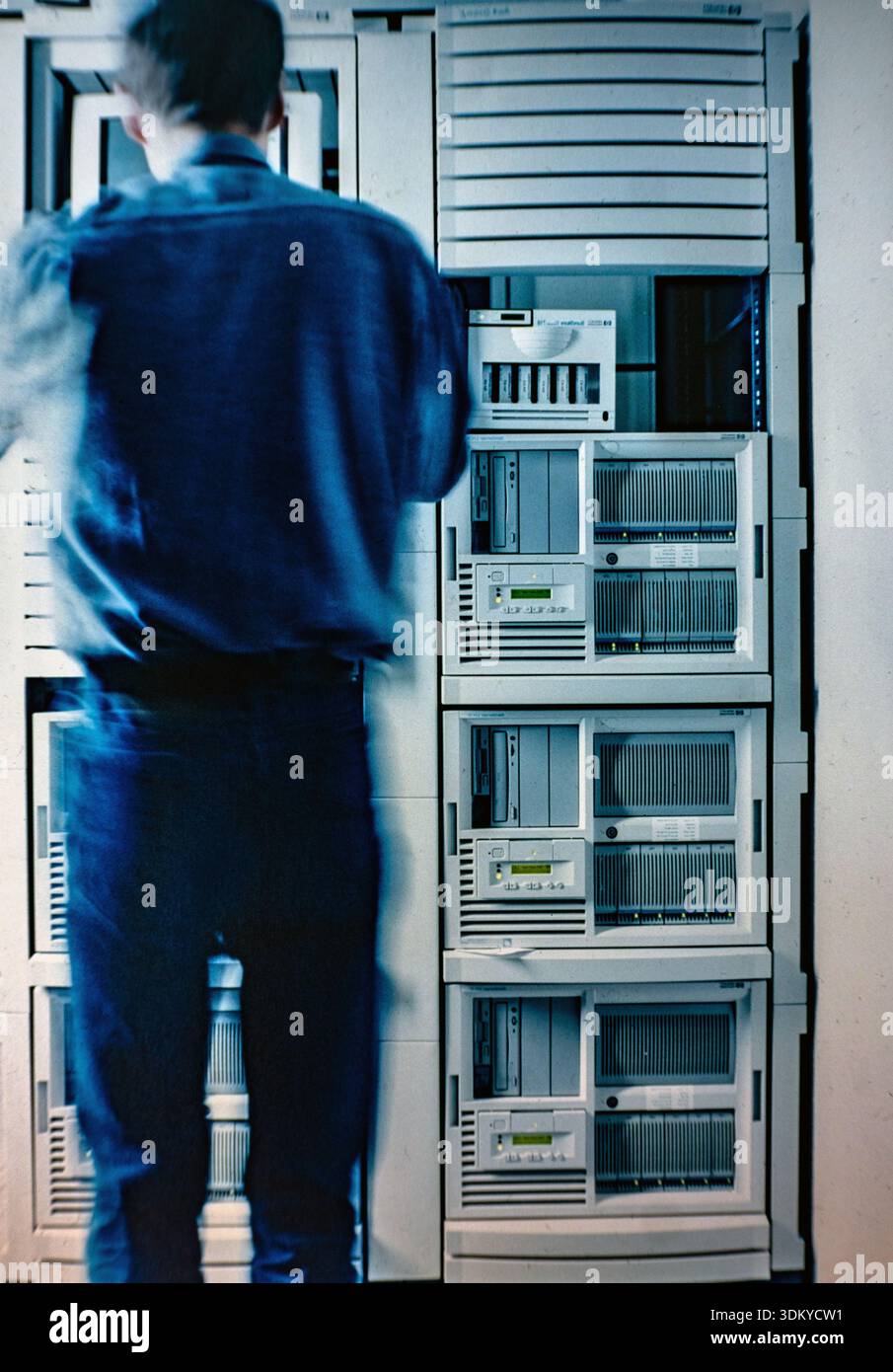 Persona che lavora in un data center con sistemi Hewlett-Packard (HP) NetServer. Si tratta di server vintage basati su x86 di livello aziendale degli anni '1990 Foto Stock