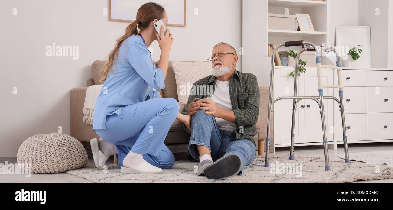 Infermiere che chiama un'ambulanza per un anziano ferito con deambulatore in casa di cura Foto Stock
