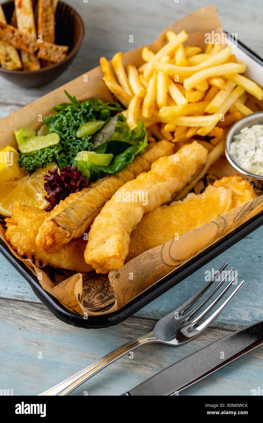 Classico fish and chips servito con patatine fritte e salsa Foto Stock