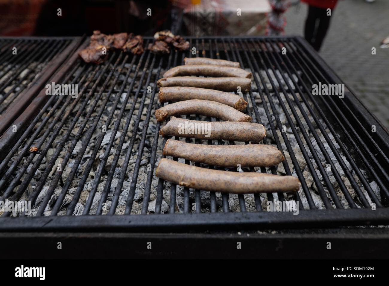 Dettagli con salsicce tradizionali rumene su una griglia in metallo carbone. Foto Stock