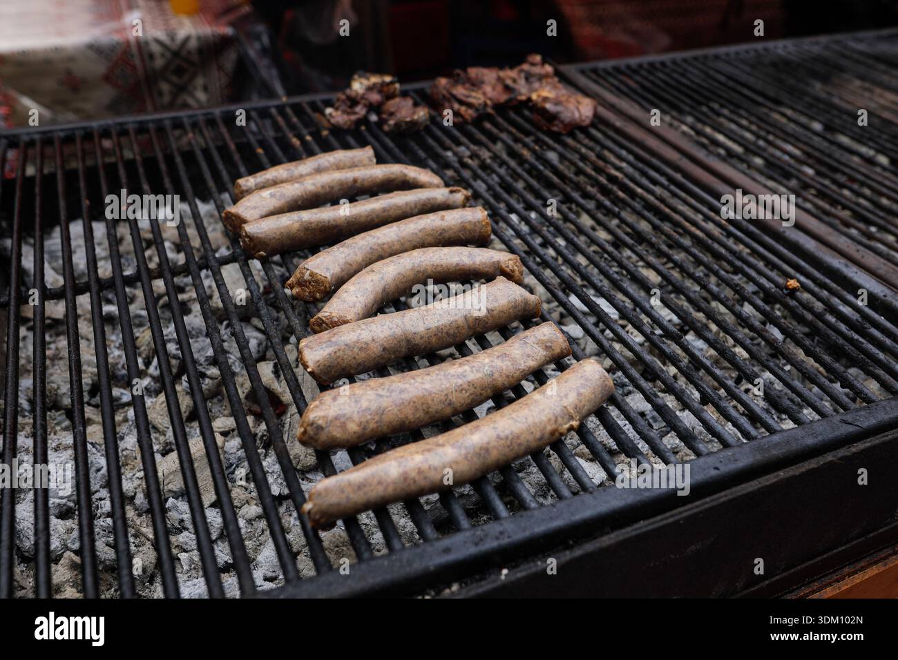 Dettagli con salsicce tradizionali rumene su una griglia in metallo carbone. Foto Stock