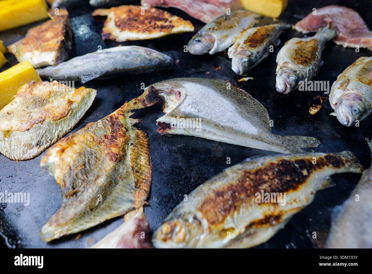 Dettagli con vari tipi di pesce su una stufa in un mercato agricolo. Foto Stock