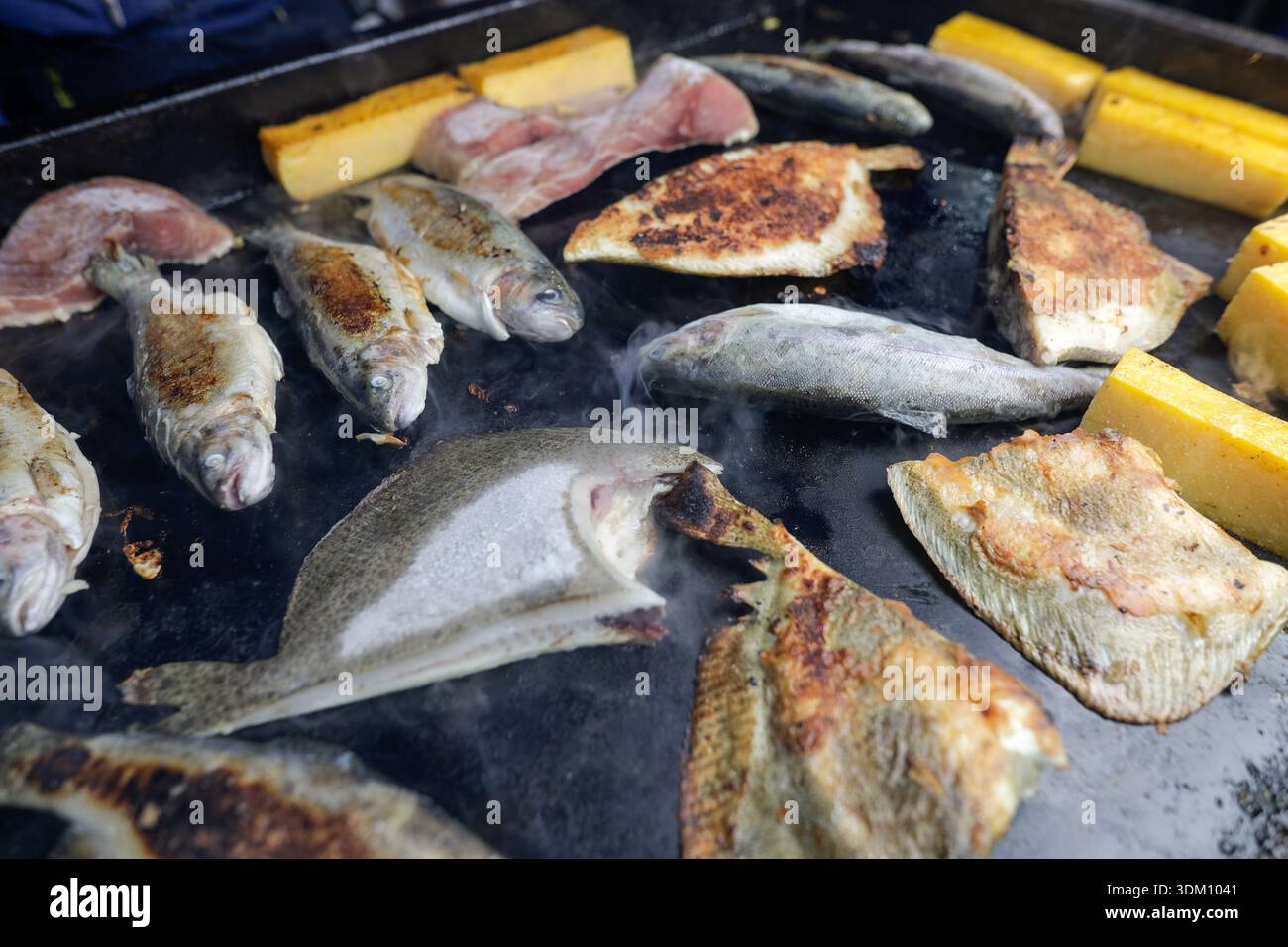 Dettagli con vari tipi di pesce su una stufa in un mercato agricolo. Foto Stock