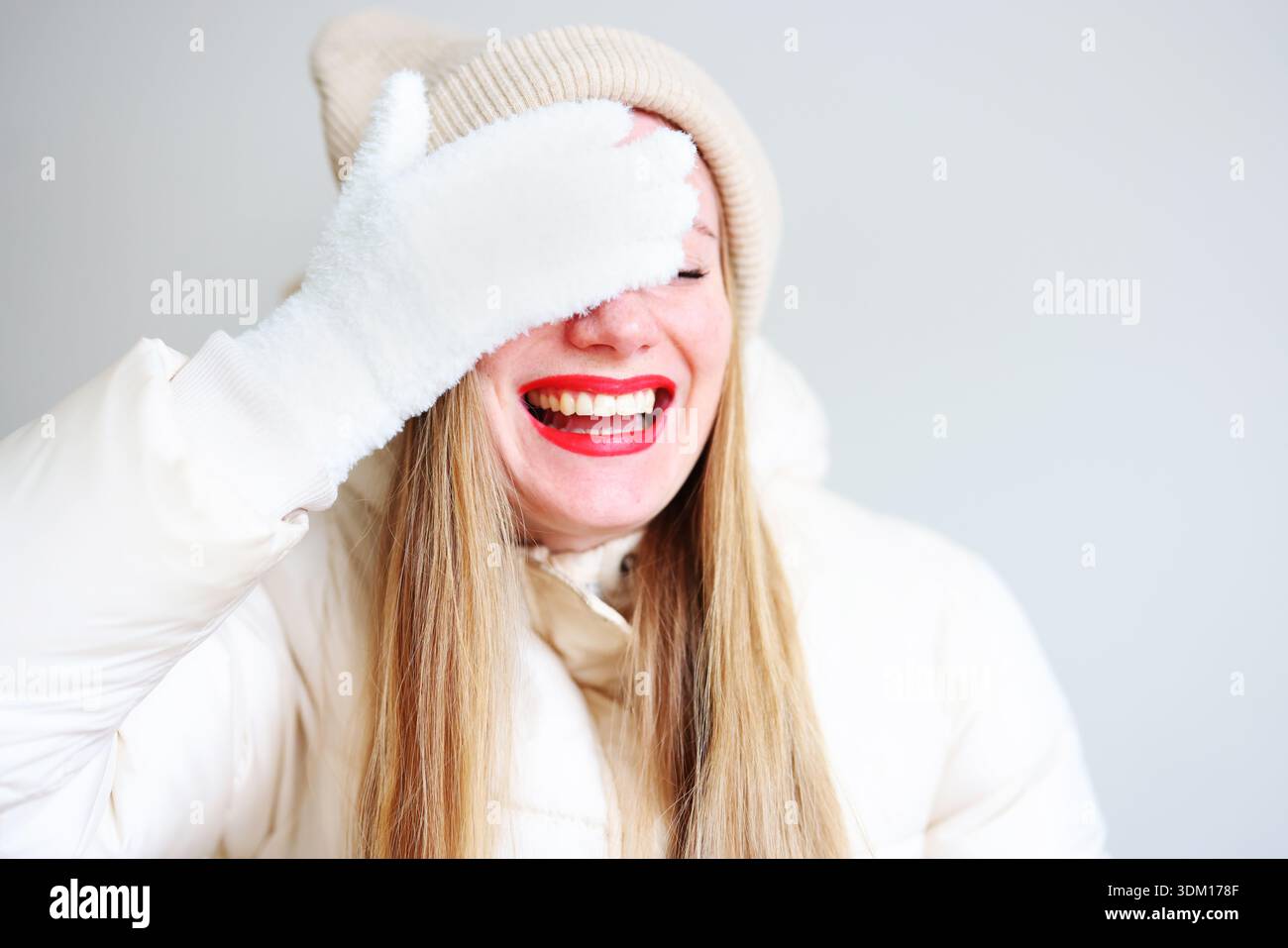 Gioioso ritratto invernale di donna sorridente in abiti caldi con rossetto rosso Foto Stock