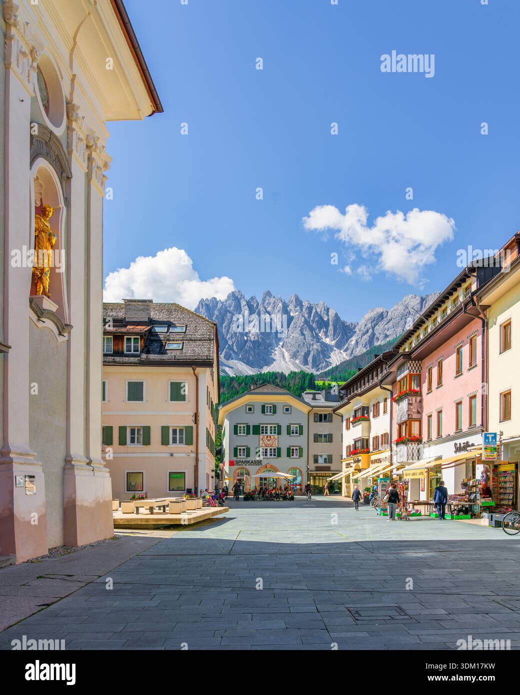 SAN CANDIDO, ALTO ADIGE - ITALIA - 27 GIUGNO 2024 Piazza pedonale centrale a San Candido, Innichen, con edifici alpini e vette dolomitiche Foto Stock