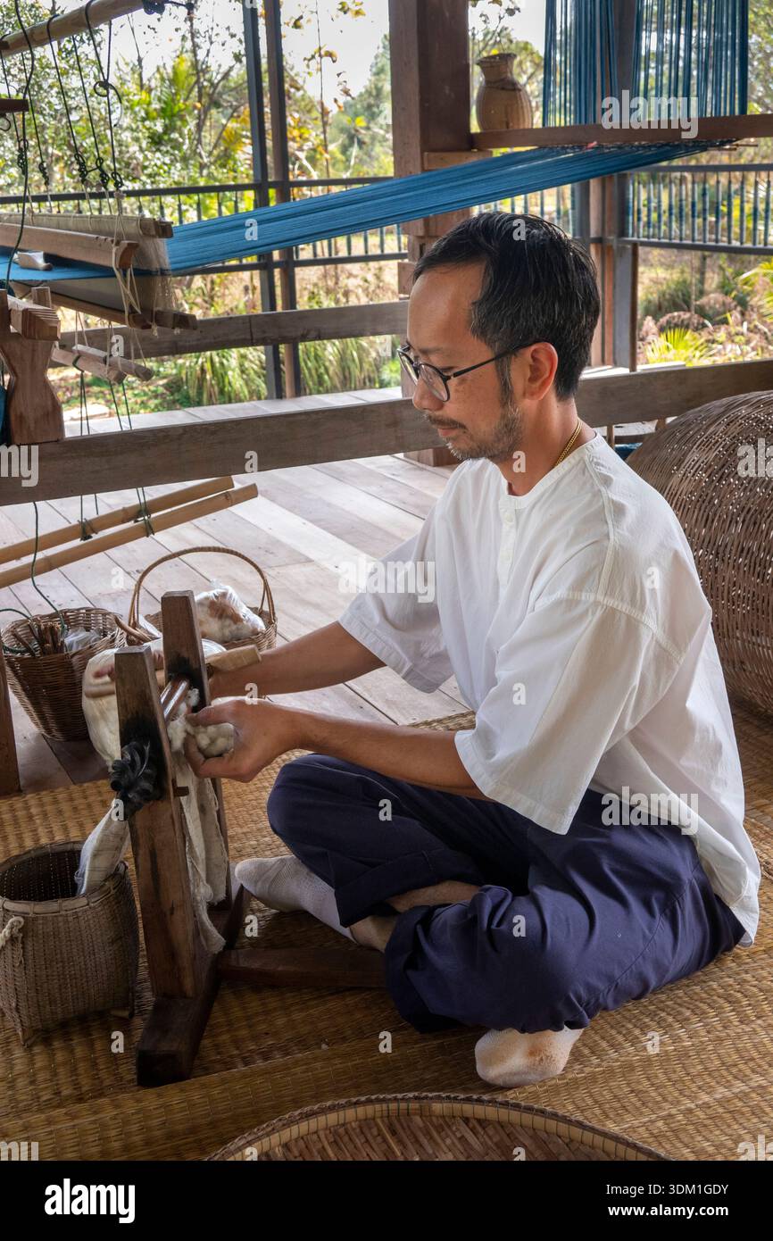 Th1523 Thailand, Isaan, Sakon Nakhon, Phang Khwang, Mann Gardens Creative Crafts Center, fondatore Prach Niyomkar che cardava cotone grezzo, allineando le fibre a. Foto Stock