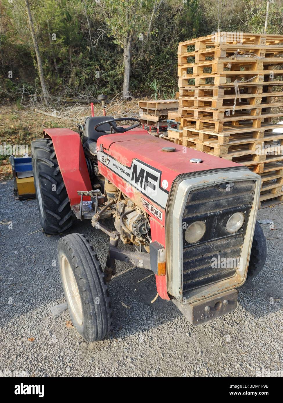 Dettaglio di un vecchio trattore rosso Massey Ferguson 247 parcheggiato sulla strada Foto Stock