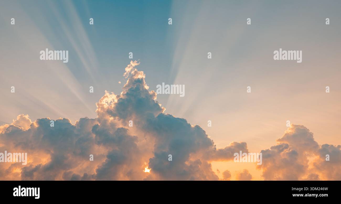 Il maestoso cielo del tramonto mozzafiato nuvole dorate arancioni raggi di sole tramonti carta da parati panoramica spettacolare paesaggio naturale all'orizzonte scenografico crepuscolo di luce Foto Stock