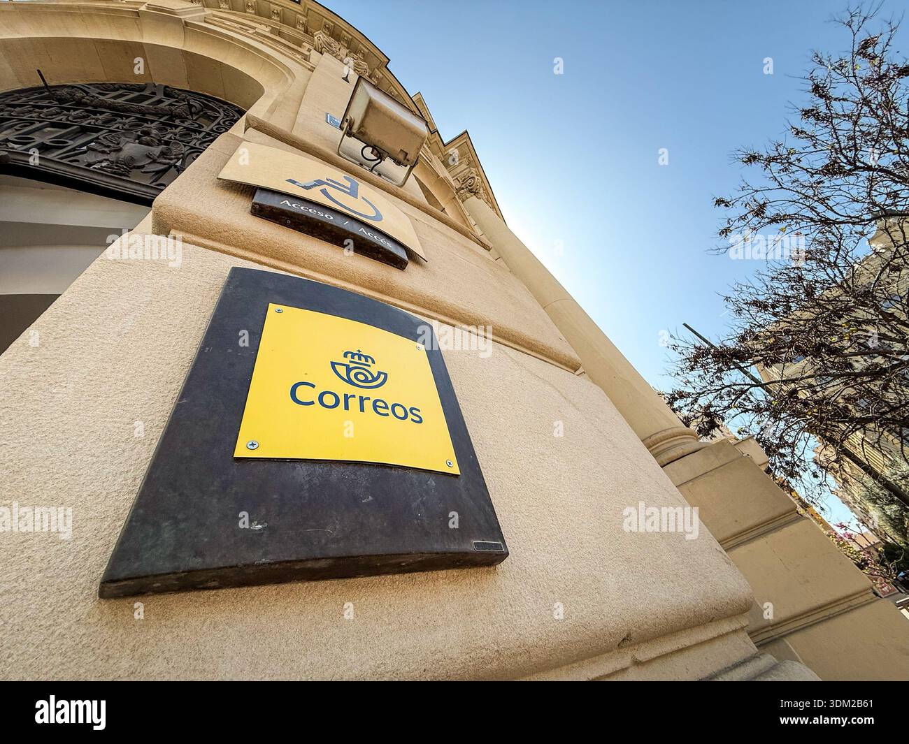 VALENCIA, SPAGNA - 7 APRILE 2025: Correos firma su un edificio del servizio postale pubblico a Valencia, Spagna, con il logo postale giallo, Correos è il centro termale Foto Stock