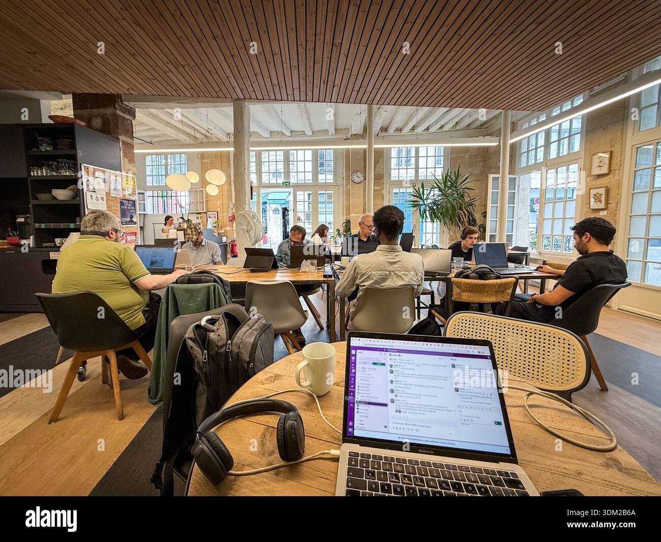 PARIGI, FRANCIA - 23 GIUGNO 2025: Persone che lavorano su computer portatili all'interno di uno spazio di coworking a Parigi. L'ambiente d'ufficio condiviso riflette la moderna cultura del lavoro Foto Stock