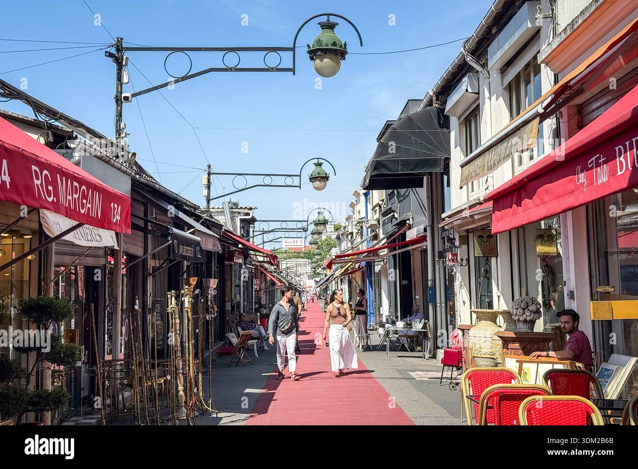 PARIGI, FRANCIA - 23 GIUGNO 2025: Vicolo principale delle Marche Biron al mercato delle pulci Marche aux puces de Saint Ouen a Parigi. Gli amanti dello shopping passano accanto ai negozi di antiquariato A. Foto Stock