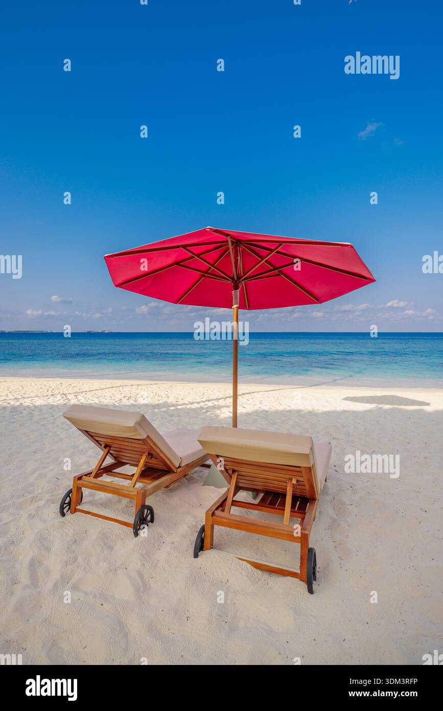 Spiaggia verticale lettini solari minimi ombrellone calmo vista sull'oceano rilassante paesaggio estivo migliore sfondo vacanza paradiso tropicale isola fuga Foto Stock