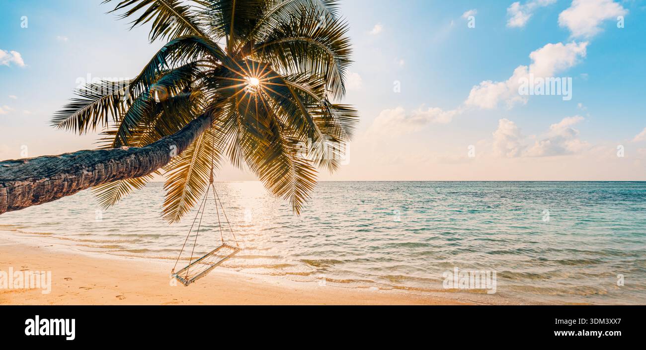 Paesaggio estivo mozzafiato per turismo balneare altalena di palme raggi del tramonto pittoresco sfondo di viaggio paradiso tropicale Foto Stock