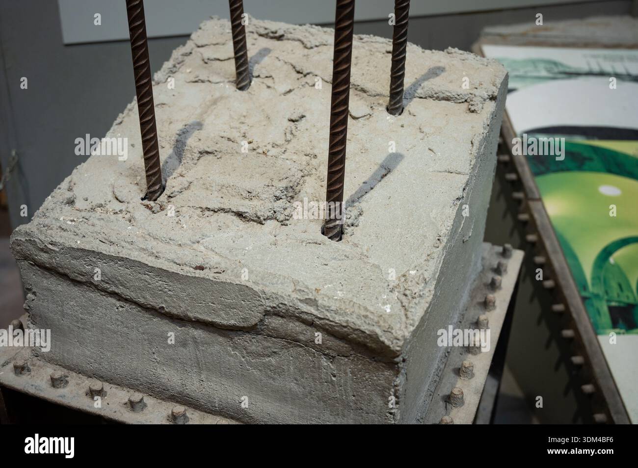 Primo piano di un modello dimostrativo di blocchi in calcestruzzo che mostra barre di rinforzo in acciaio scanalato (armature) utilizzate per la resistenza alla trazione nelle costruzioni e nei motori Foto Stock