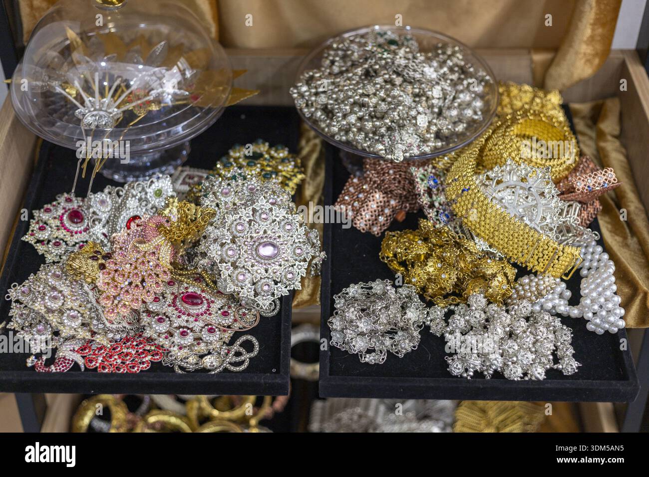 Splendida collezione di accessori e gioielli tradizionali. decorazioni artigianali ornamentali in oro e argento e copricapo intricate, scintillanti, Foto Stock