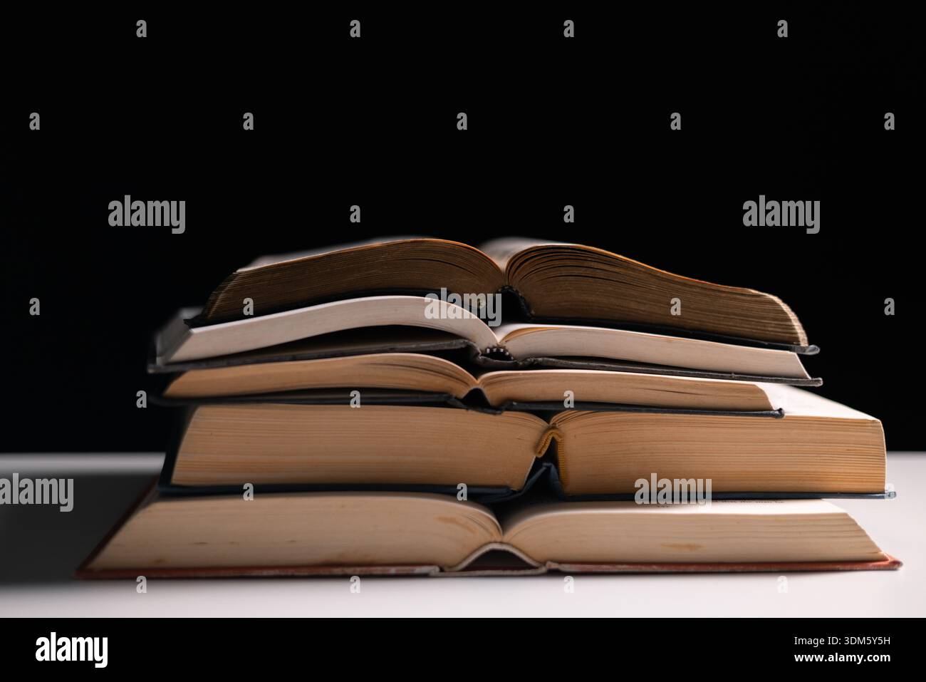 Vecchia biblioteca, una Bibbia aperta giaceva sul tavolo, le sue sacre pagine di scritture illuminate nella stanza buia. bibbia, santa, oscura, vecchia, aperta, libreria, pagine, s. Foto Stock