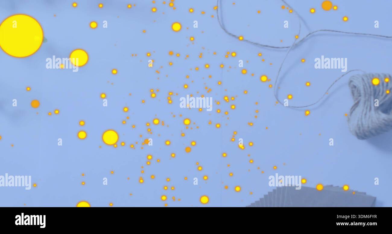 Puntini gialli luminosi che coprono il piano portapaziente blu pallido, con spago e carta impilata Foto Stock