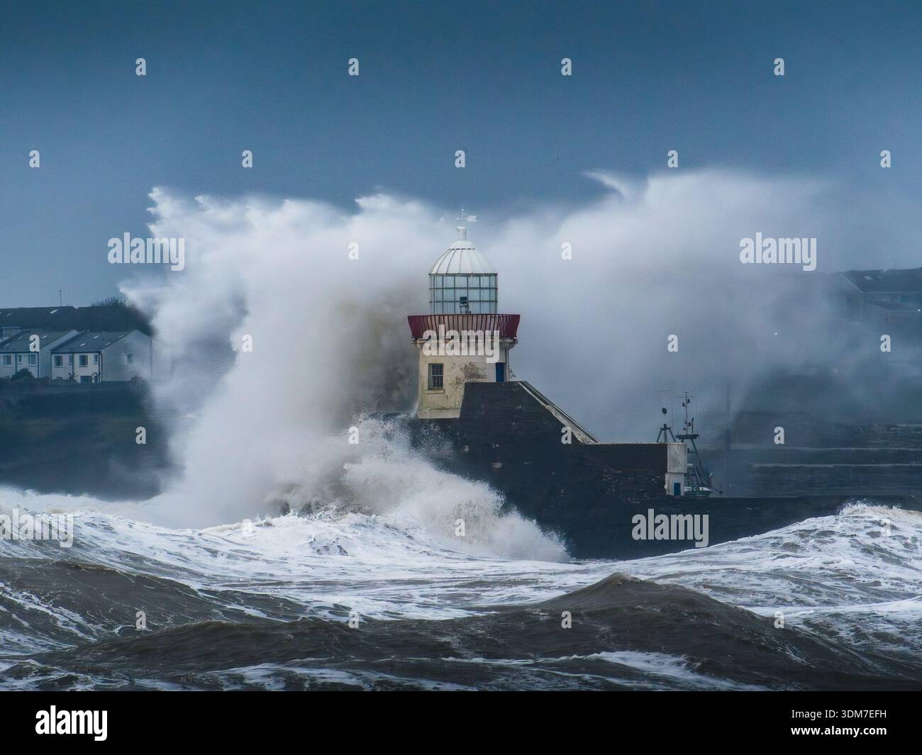 Grandi onde colpiscono il faro di Balbriggan durante una marea primaverile verso est Foto Stock