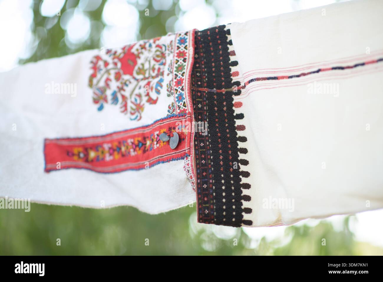 Primo piano di due autentiche maniche in tessuto bulgaro che presentano ricami intricati con vivaci motivi rossi, neri e multicolori, che rappresentano la t Foto Stock