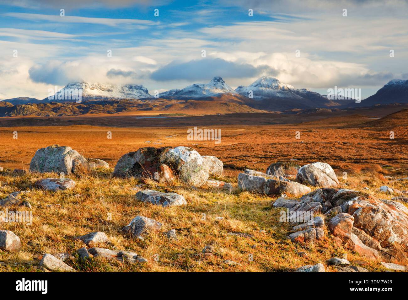 Massi nelle ventose Highlands scozzesi con le montagne innevate di Suilven e Stack Polly sullo sfondo, Achnahaird nel nord-ovest della Scozia Foto Stock