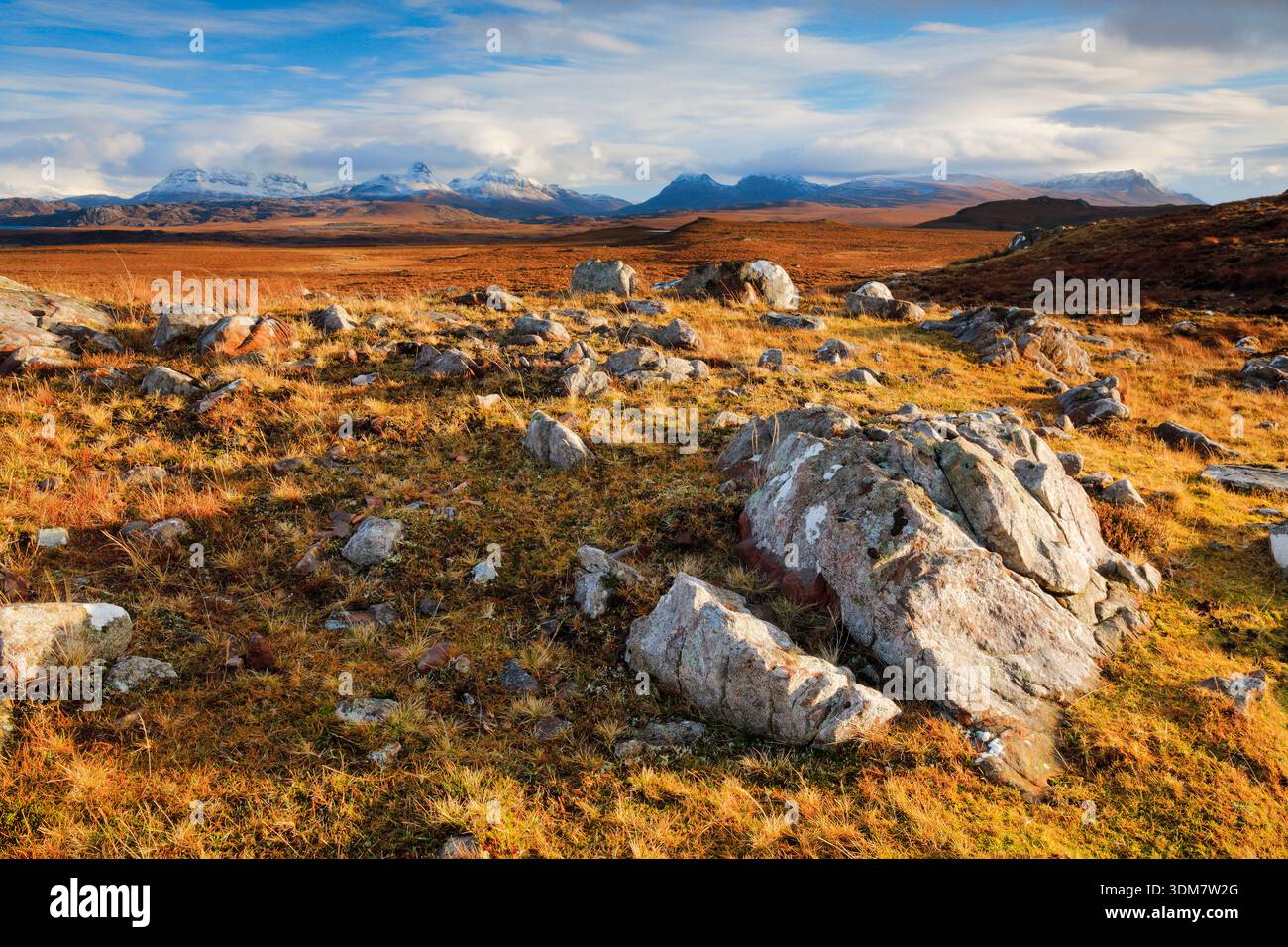 Massi nelle ventose Highlands scozzesi con le montagne innevate di Suilven e Stack Polly sullo sfondo, Achnahaird nel nord-ovest della Scozia Foto Stock