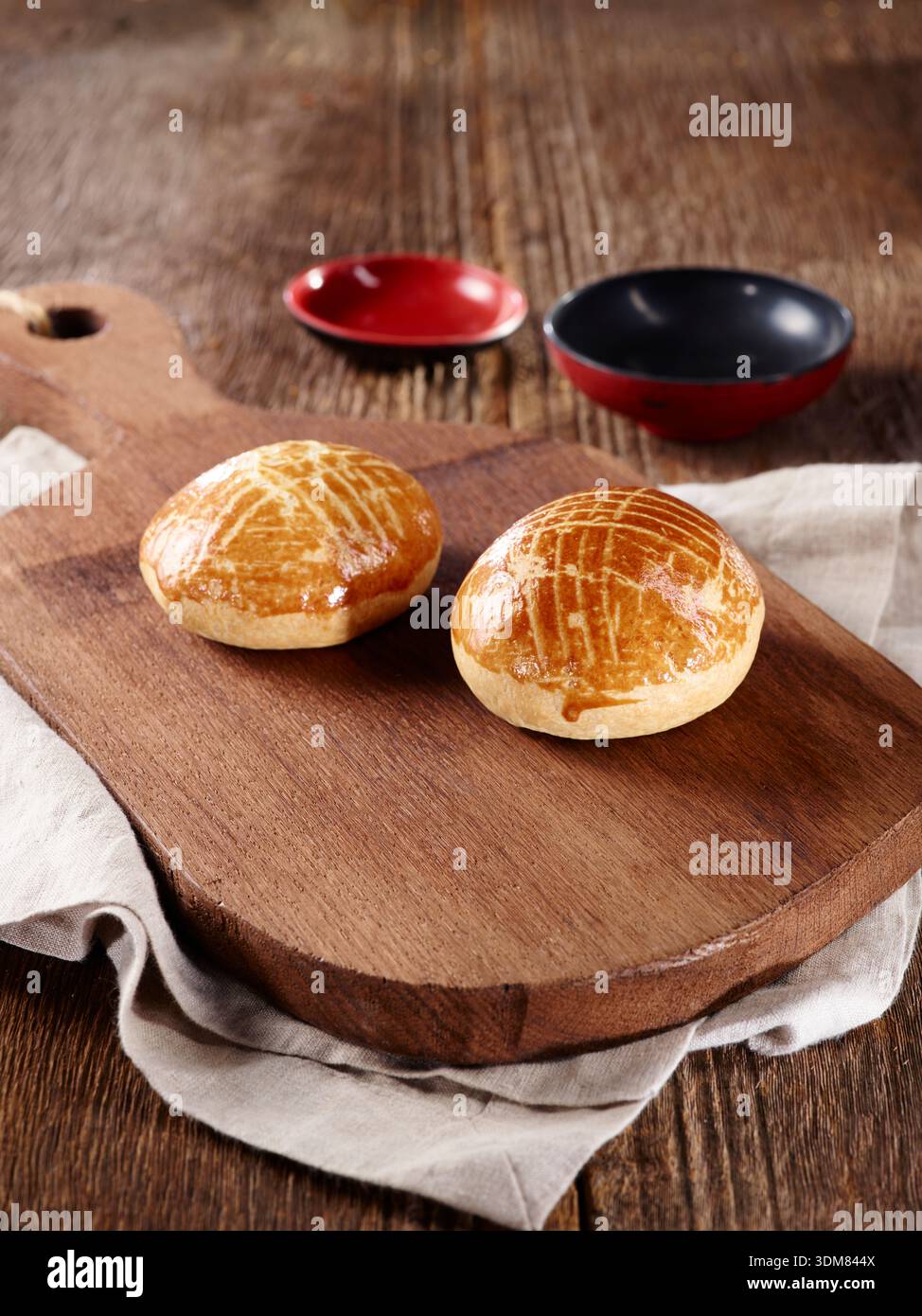 Panini chiamati poğaça su una tavola di legno rustica con ciotole Foto Stock