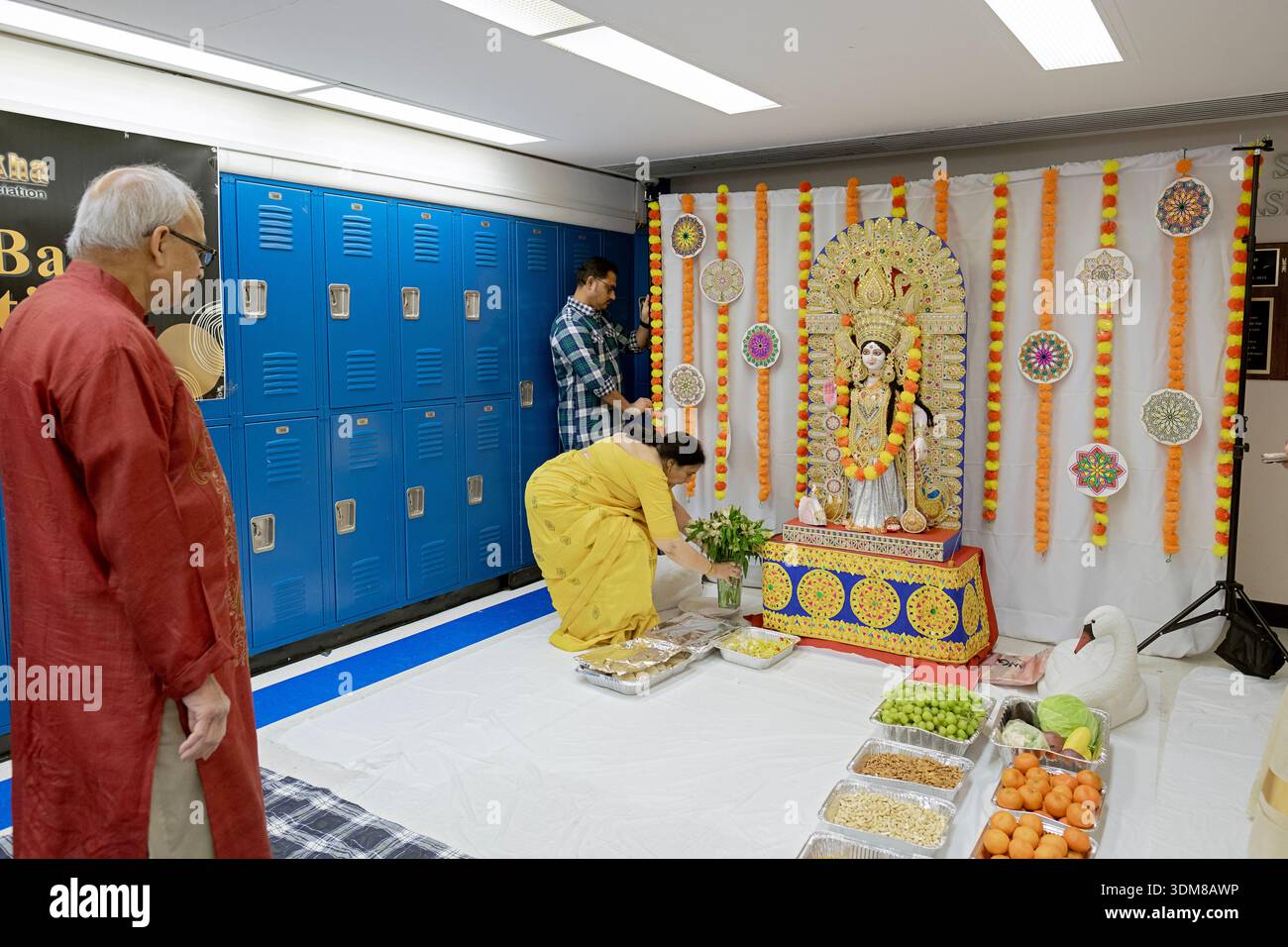 Devoti indù americani preparano un altare per una puja alla dea Saraswati all'interno della Blind Brook Middle Highschool di Rye Brook, New York. Foto Stock
