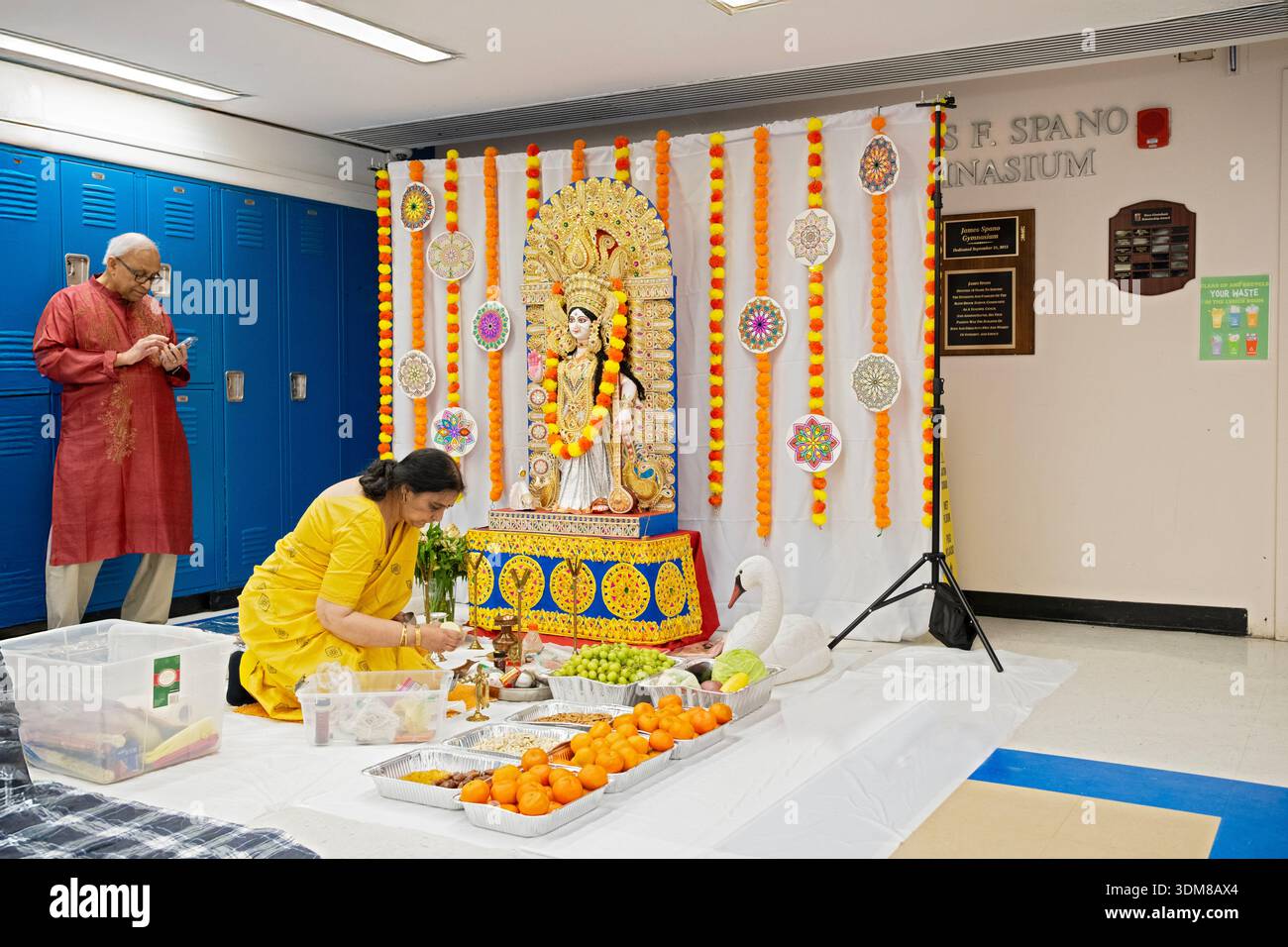 Devoti indù americani preparano un altare per una puja alla dea Saraswati all'interno della Blind Brook Middle Highschool di Rye Brook, New York. Foto Stock