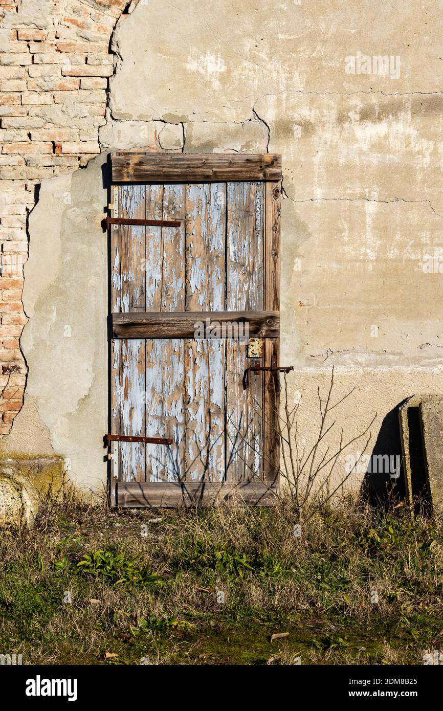 Porta di campagna con texture vintage, legno rustico, vernice blu e vecchio intonaco. Foto Stock