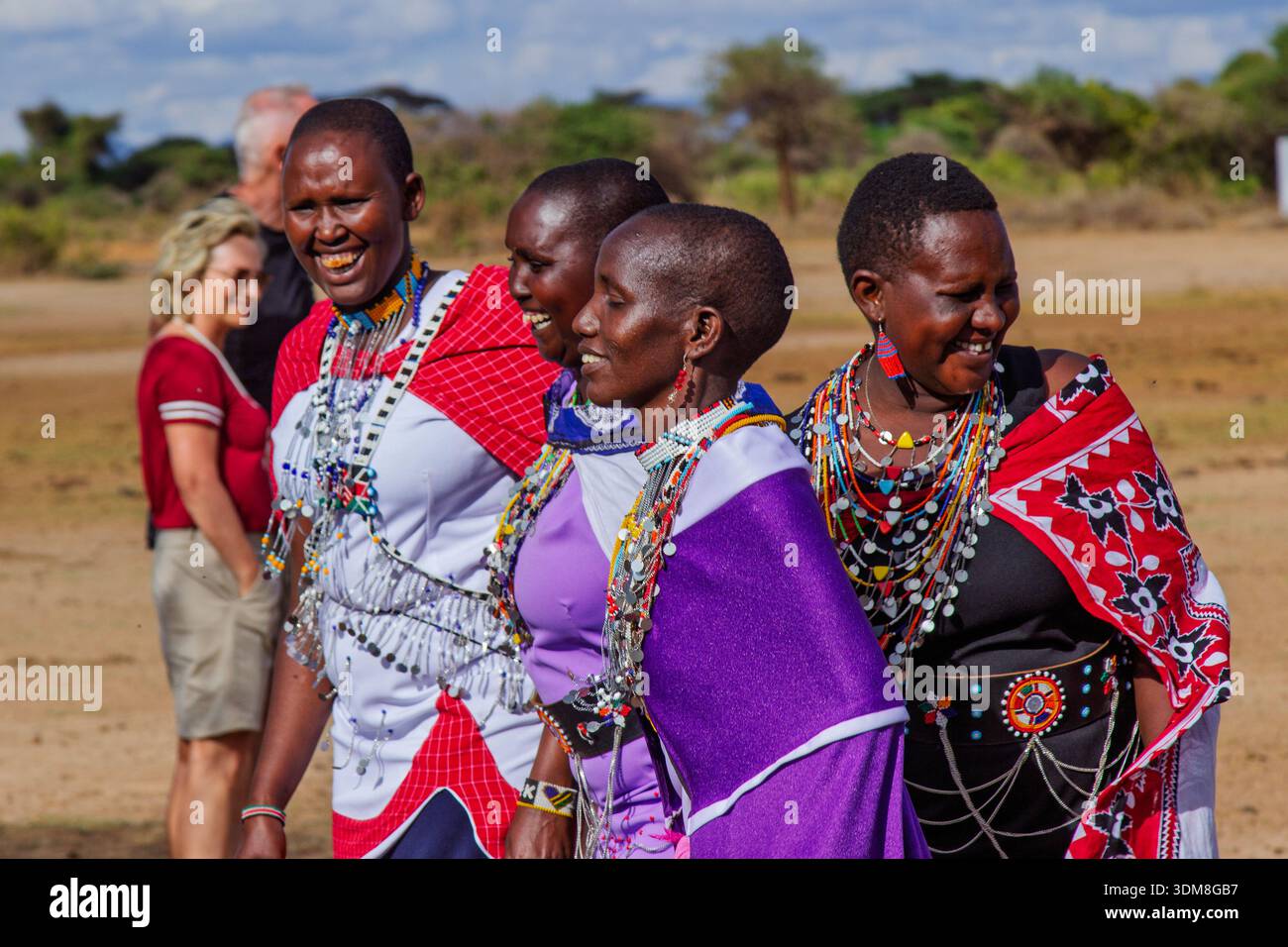 Le donne Maasai in Kenya, adornate con abiti tradizionali, condividono un momento di gioia, mostrando la loro vibrante cultura. Foto Stock