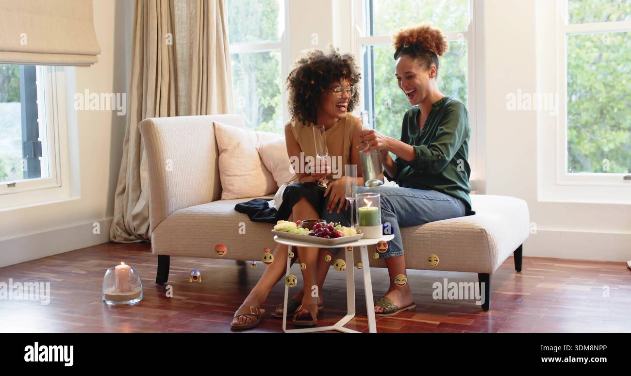 Una donna che versa in camicetta verde e un'amica che stringe i bicchieri, seduto su un amorino beige con frutta Foto Stock