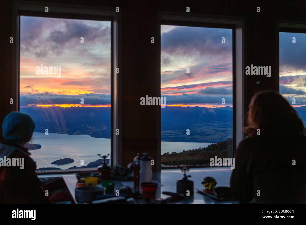 Gli escursionisti all'interno della Luxmore Hut si affacciano sul lago te Anau, te Anau, South Island, nuova Zelanda Foto Stock