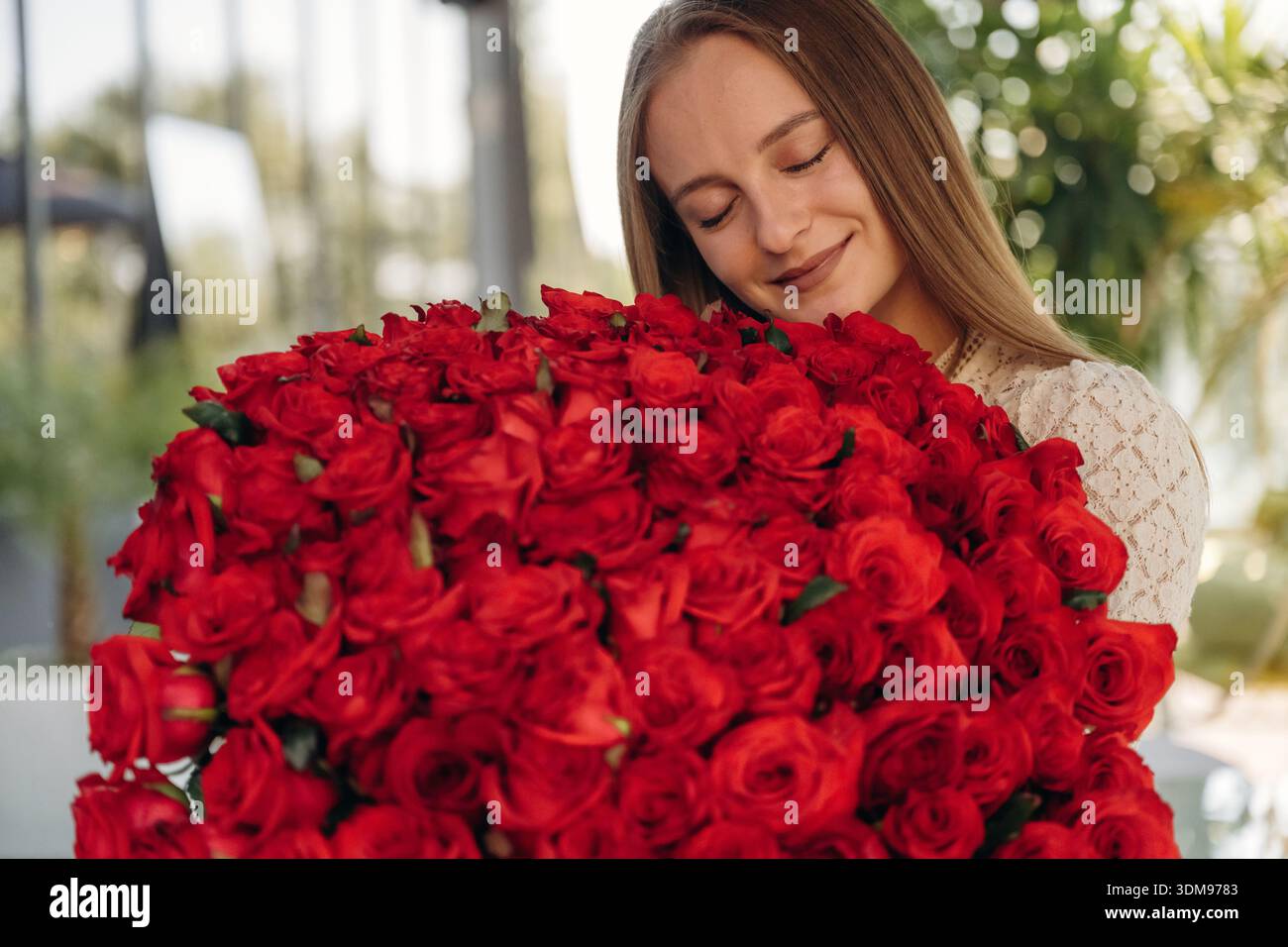 La giovane donna felice è con un grande bouquet di rose. Foto Stock