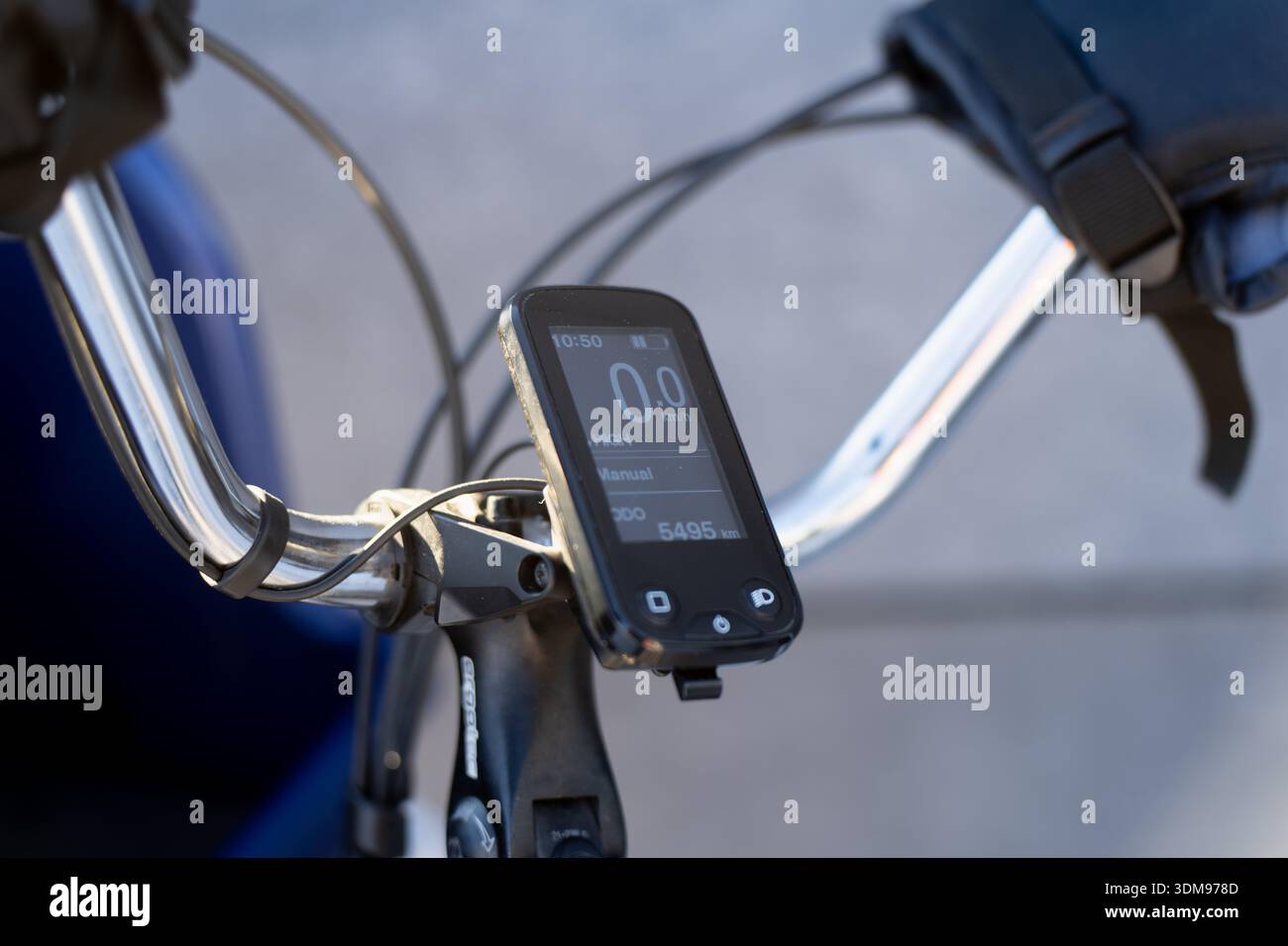Display digitale del computer per bici sul manubrio della bicicletta con cavi e supporto, primo piano della moderna tecnologia ciclistica per pendolarismo, formazione e navigazione Foto Stock