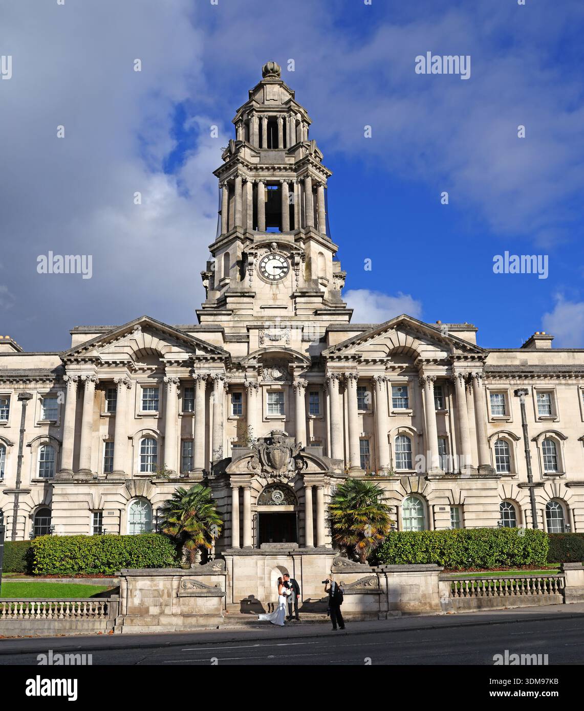 Il municipio di Stockport su Wellington Road, sotto il sole invernale, con una sposa e uno sposo fuori dall'ingresso dopo una cerimonia di nozze, Stockport Foto Stock