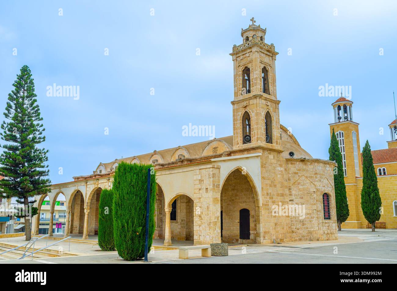 Facciata in pietra medievale della vecchia chiesa di Agios Georgios con ingresso terrazzato e campanile, Protaras, Cipro. Foto Stock