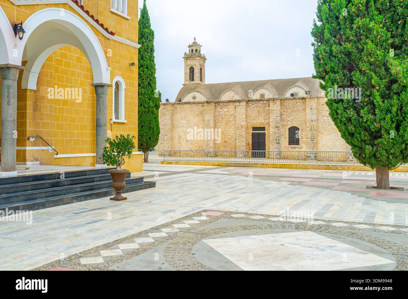 L'ingresso alla cattedrale di Santa Varvara con la chiesa medievale di Agios Georgios sullo sfondo, Paralimni, Cipro. Foto Stock