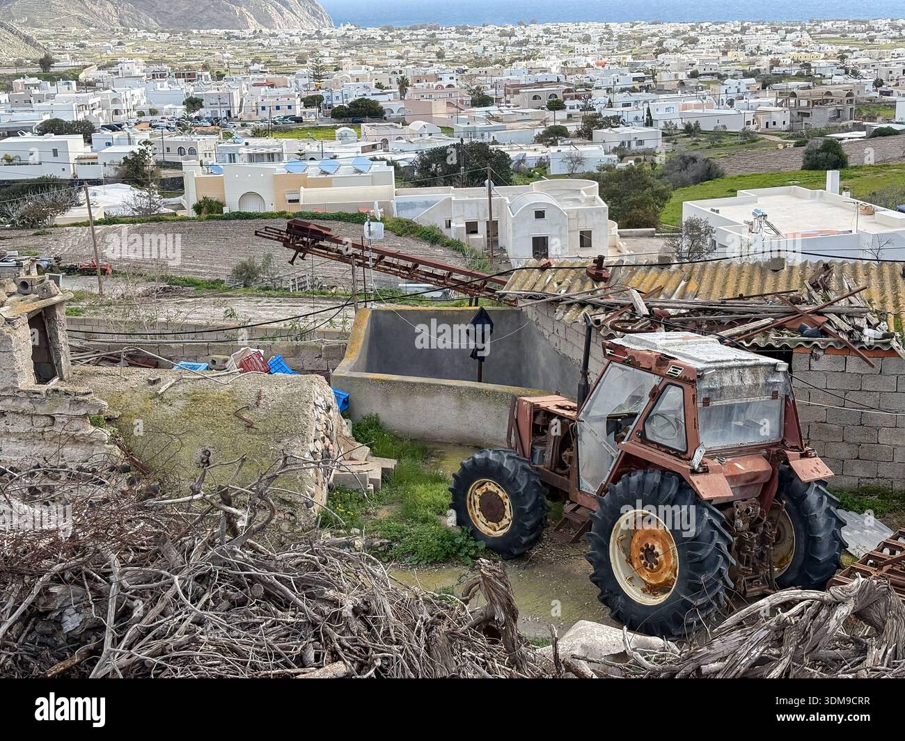 Vecchio trattore multiuso arrugginito, macchinari agricoli, paesaggio rurale in decadenza vicino al villaggio Emporio, all'isola di Santorini, in Grecia. Veicolo agricolo rustico. Foto Stock
