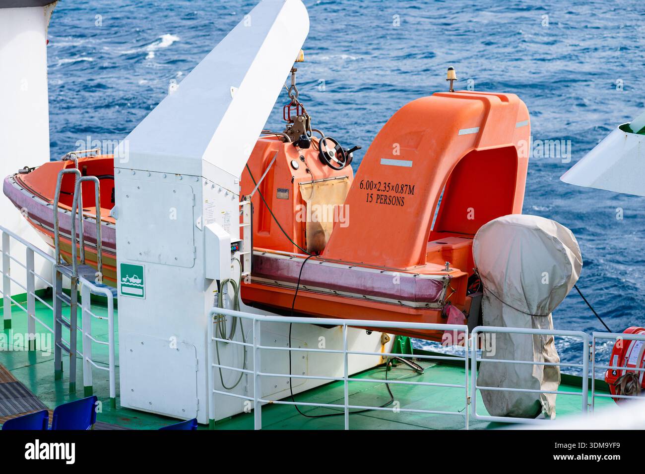 Scialuppa di salvataggio arancione fissata sul ponte della nave che rappresenta l'equipaggiamento di sicurezza e le operazioni di trasporto marittimo. Foto Stock
