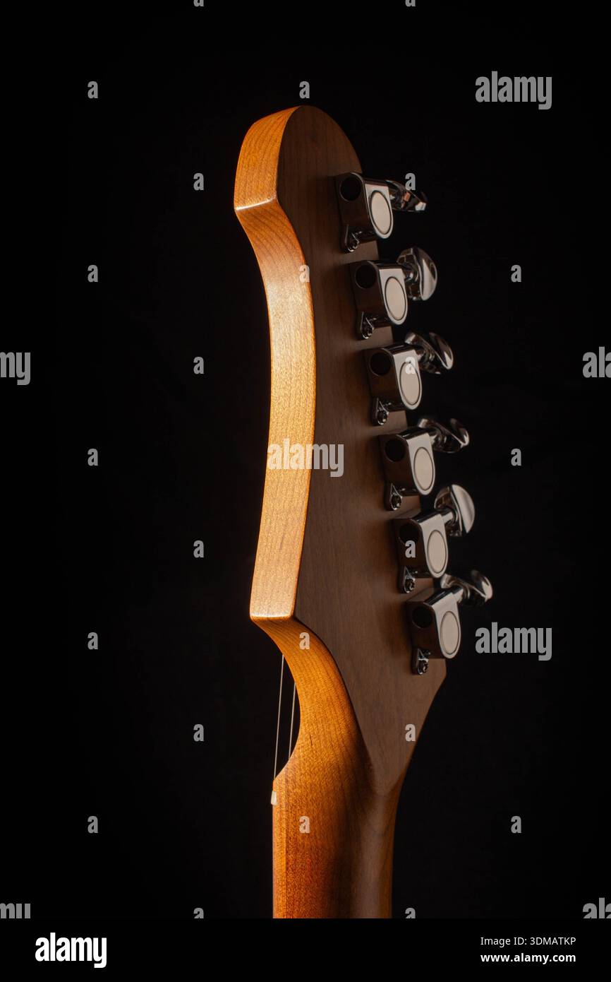 Foto in studio del retro di una testa di chitarra elettrica con finitura in legno satinato e grana naturale. Foto Stock