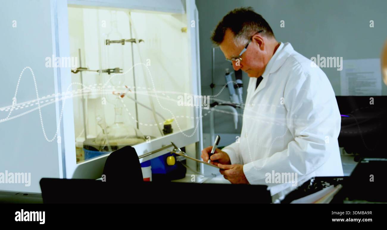 Scrivendo un chimico senior che indossa un camice da laboratorio bianco e prende appunti al banco con la fiasca della cappa chimica Foto Stock