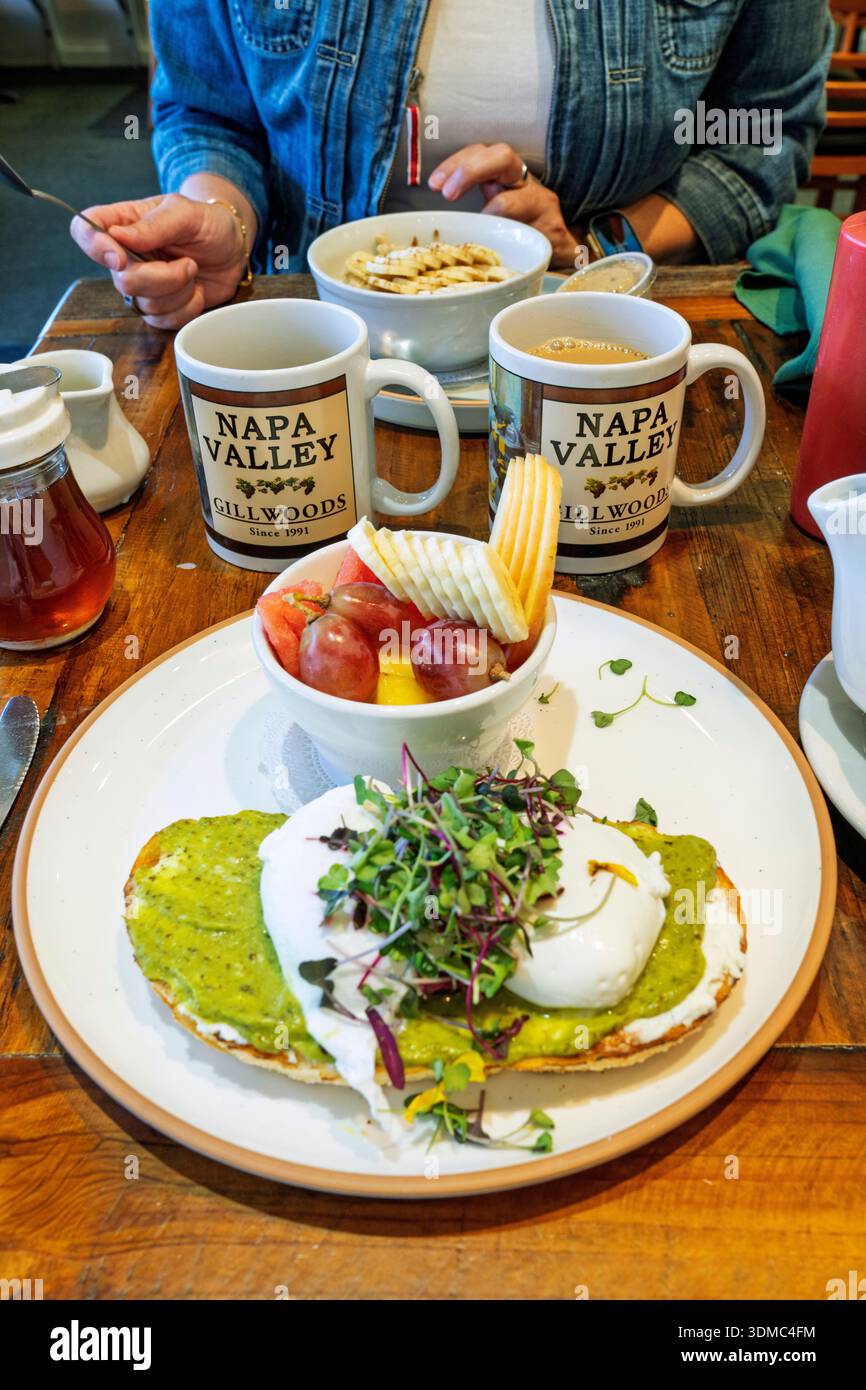 Toast all'avocado con uova in camicia, colazione al Gillwoods Cafe nel centro di St. Helena, Napa Valley, Napa County, California, Stati Uniti. Foto Stock