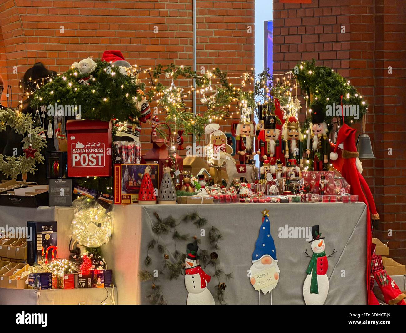 Poznan, Polonia - 18 novembre 2025: Bancarelle natalizie piene di personaggi dello schiaccianoci, scatola di Santa Post e luci accese per lo shopping natalizio Foto Stock