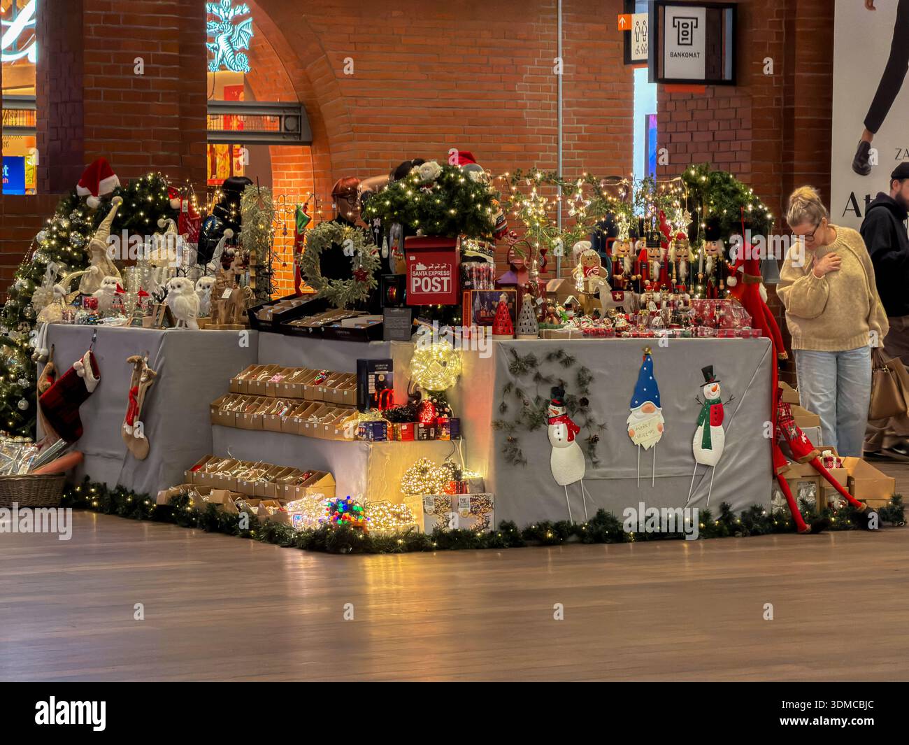Poznan, Polonia - 18 novembre 2025: La banchina del mercatino di Natale al coperto presenta diverse decorazioni natalizie, noci, gnomi e vari regali stagionali Foto Stock