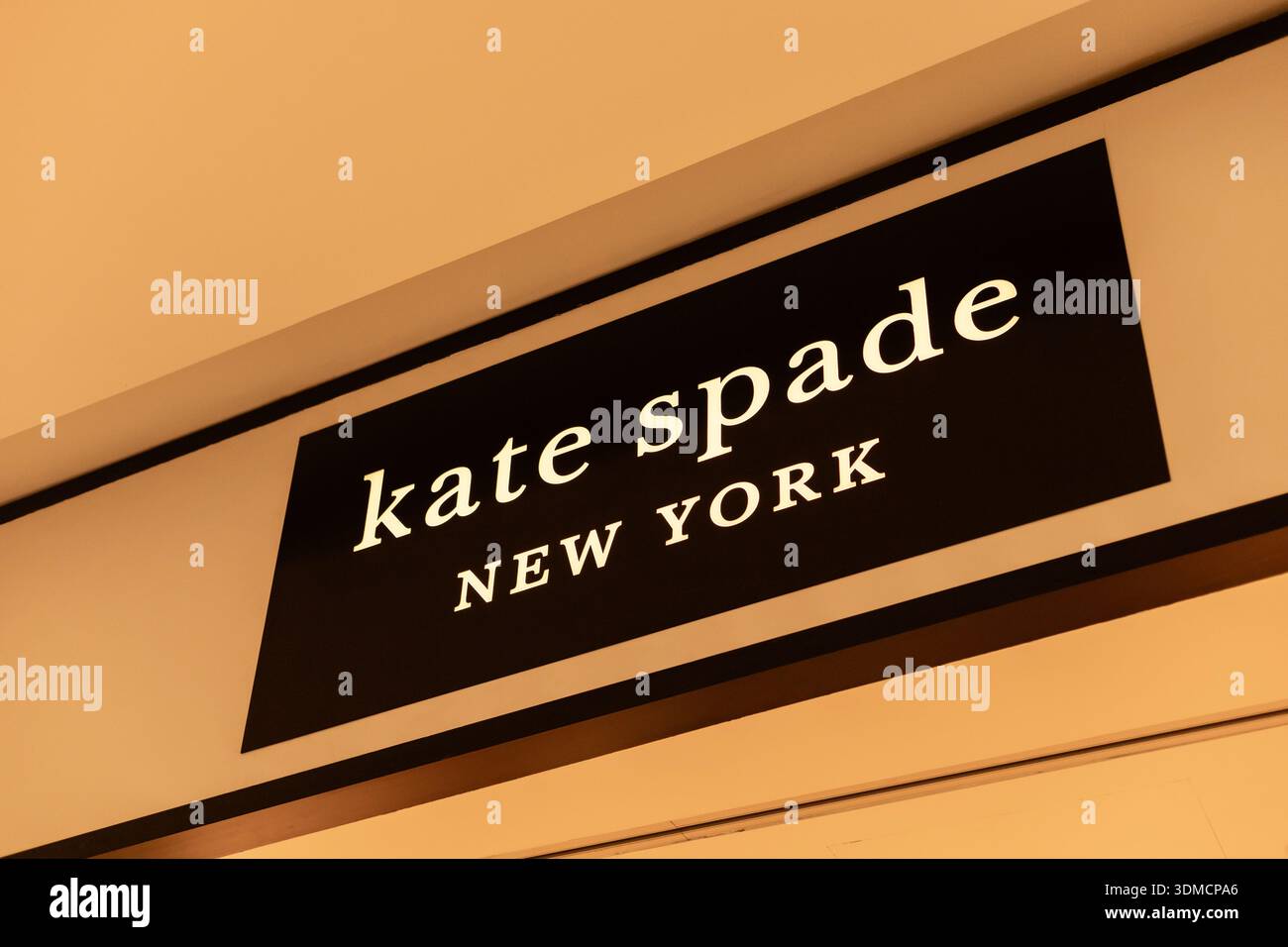 Singapore - 27 gennaio 2026: Un cartello per Kate Spade situato in una zona commerciale di Singapore. Il cartello mostra il nome del marchio e la città. La gente passa Foto Stock