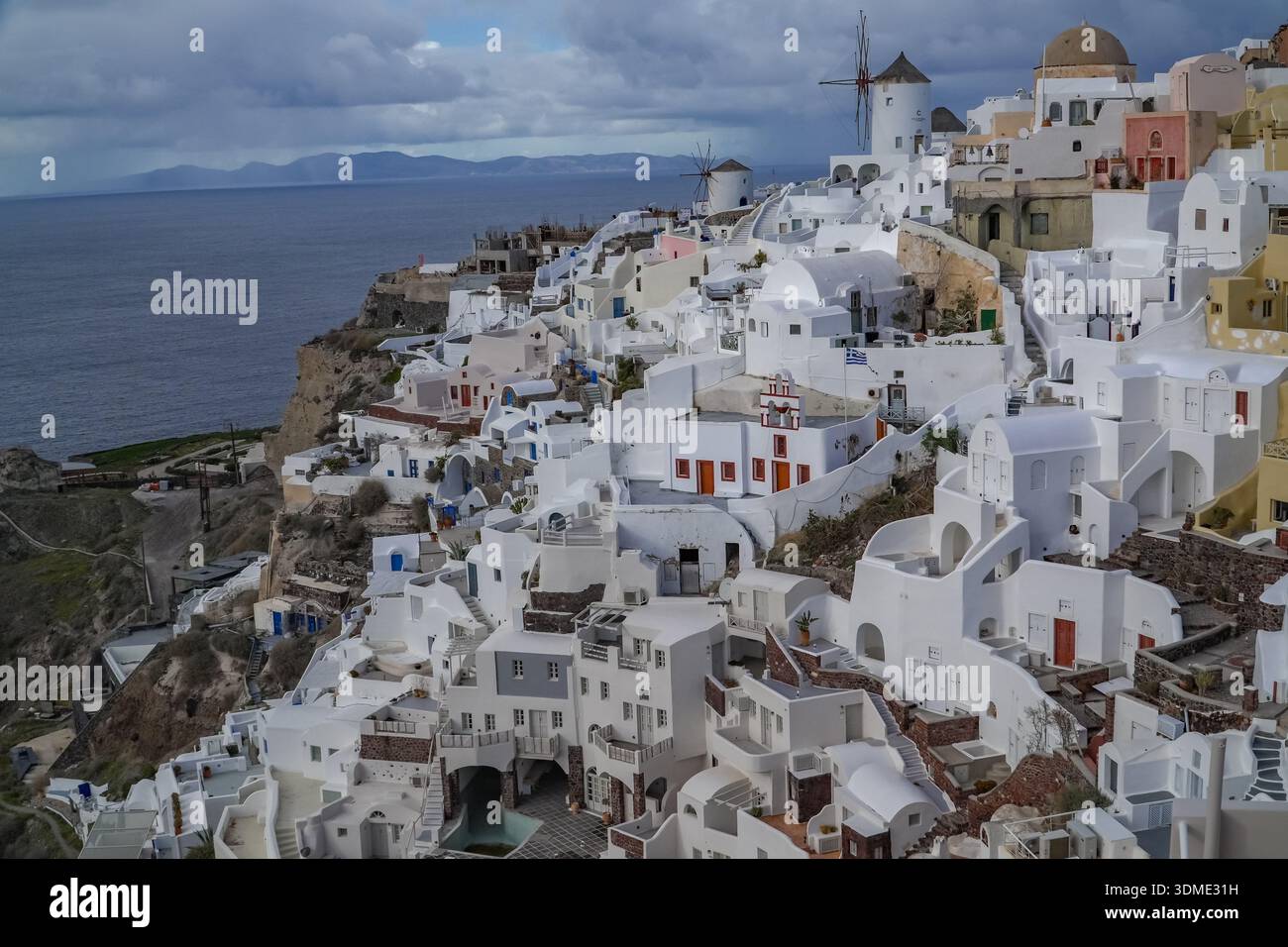 Villaggio di Oia (Apano Meria/Pano Meria), Santorini, Grecia. Iconica architettura delle Cicladi dipinta di bianco, mulini a vento e sfondo del Mar Egeo. Foto Stock