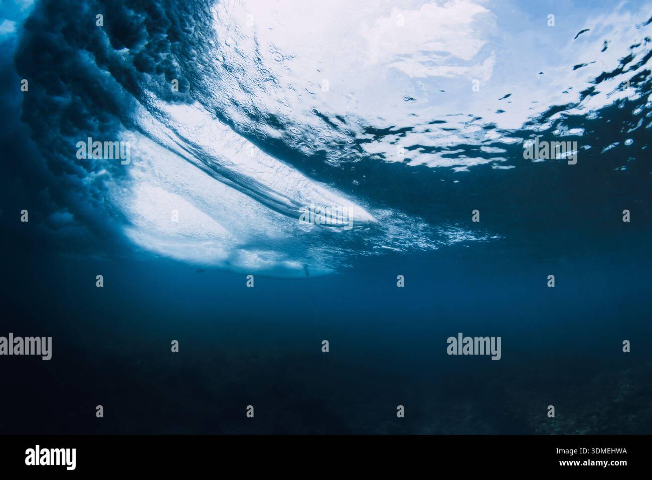 Vista subacquea del surfista che cavalca con tavole da surf e onde oceaniche che si infrangono Foto Stock
