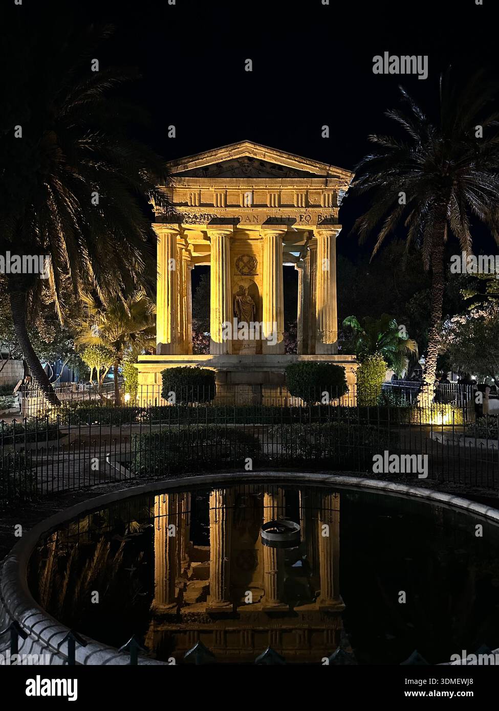 Maestoso monumento neoclassico a Sir Alexander Ball illuminato di notte con riflessi d'acqua, la Valletta, Malta, maggio 2025 Foto Stock